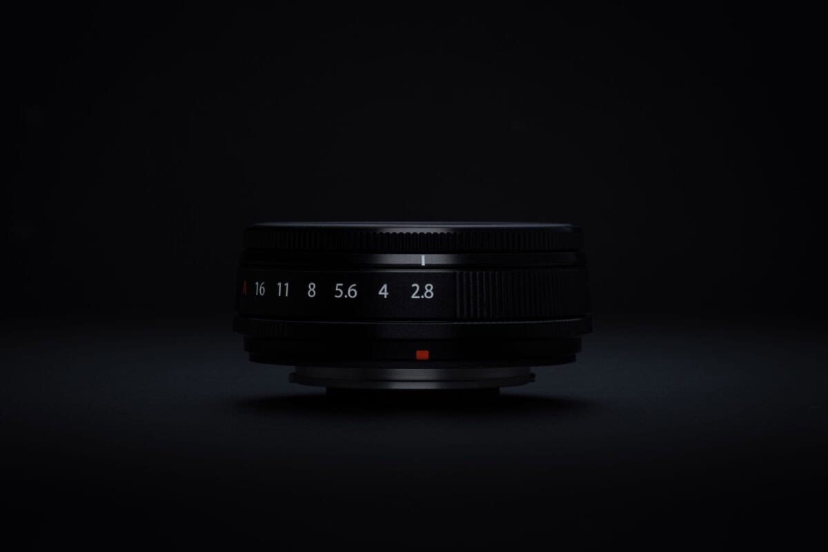 Fujifilm XF23mm F2.8 R WR Objektiv auf schwarzem Hintergrund.